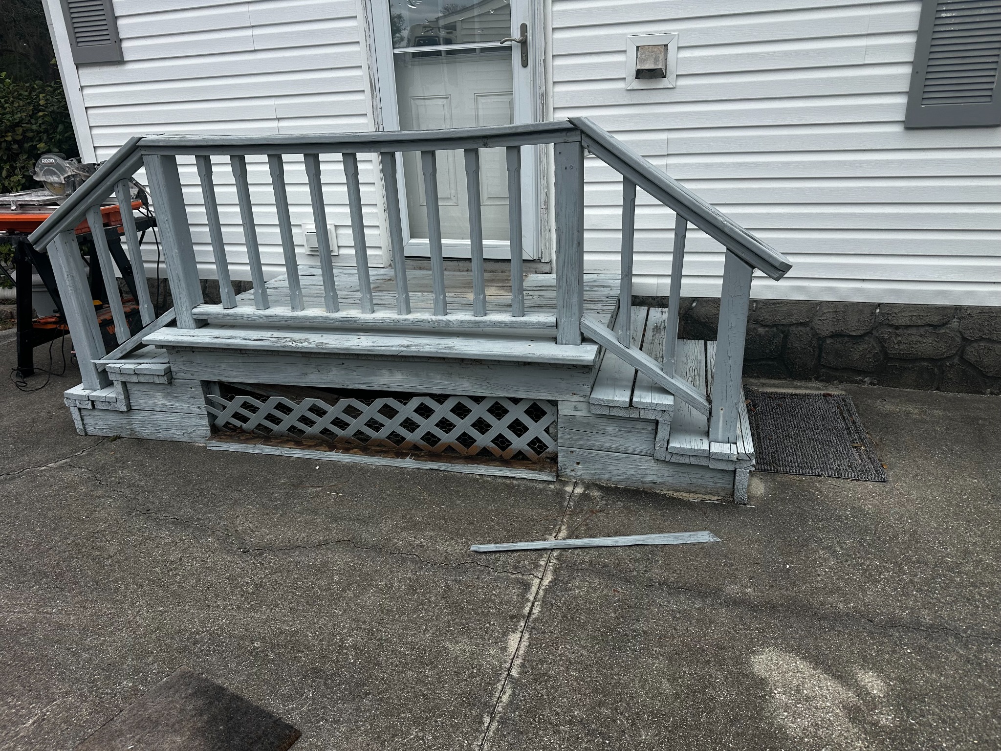 The weathered, painted entry and railing before work began.